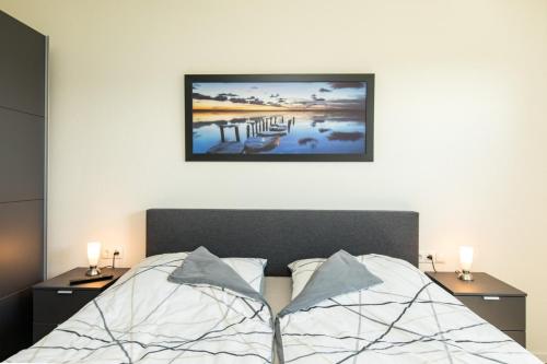 a bedroom with a bed with two night stands and two lamps at Quartier Hohe Geest 16 - Lena - a69851 in Cuxhaven