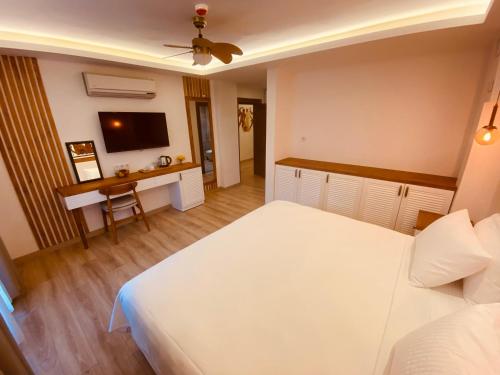 a bedroom with a large white bed and a desk at in Ephesus Hotel and Art Galery in Selcuk