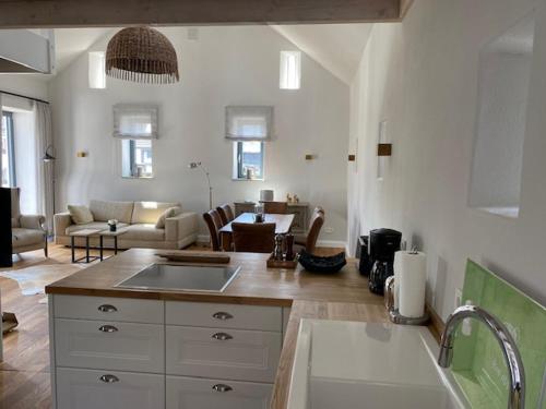 Una cocina con fregadero y una sala de estar. en Das Alte Bürgermeisteramt, en Kerpen