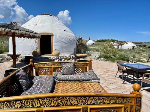 a bed in front of a yurt with a table and chairs at Ak-Tengir Yurt Resort in Tossor