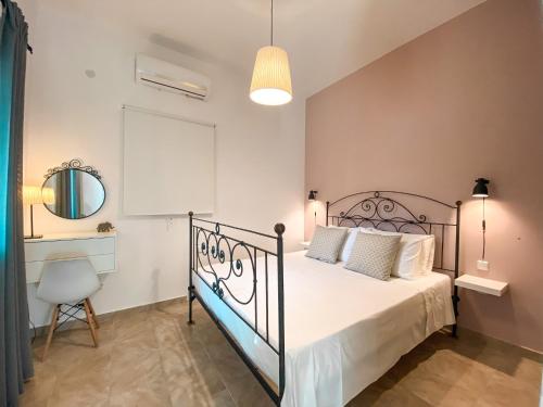 1 dormitorio con cama, silla y espejo en Olivar Holiday House en Alykes