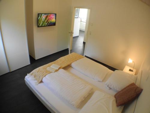a large white bed in a room with a mirror at Carpe Diem - Nordhorn in Nordhorn