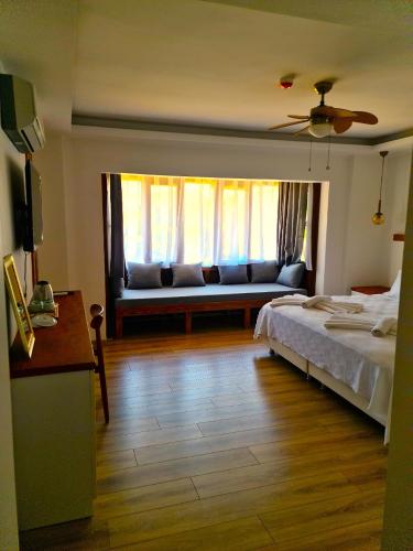 a bedroom with a bed and a couch and a window at in Ephesus Hotel and Art Galery in Selcuk