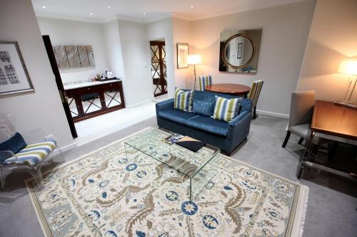 a living room with a blue couch and a table at Indaba Hotel, Spa & Conference Center in Johannesburg