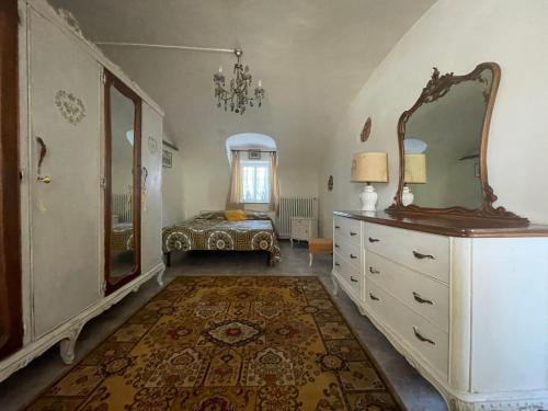 um quarto com uma cama e uma cómoda com um espelho em B&B CM Ranch em Cuneo