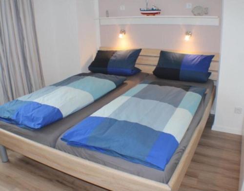 Duas camas num quarto com lençóis azuis e brancos em Sonnendeck 34 - Großenbrode em Grossenbrode
