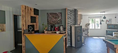 a kitchen and living room with a counter in a room at Villa Carpe Diem avec piscine et SPA in Saint-Philbert-de-Bouaine