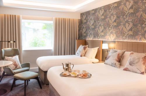a hotel room with two beds and a chair at Hotel Kilkenny in Kilkenny