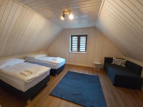 a attic bedroom with two beds and a blue rug at Domek Paralotniarza in Borsk