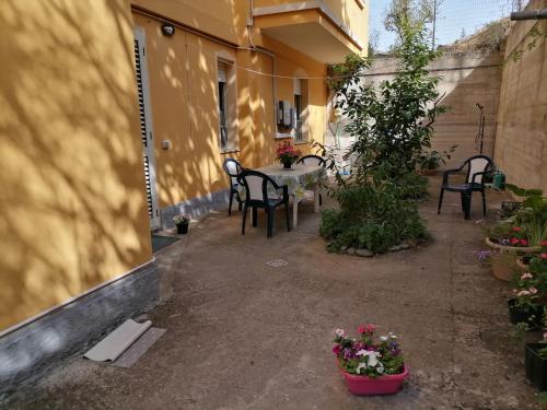 an outdoor patio with a table and chairs and flowers at Stella Del Sud in Cuglieri