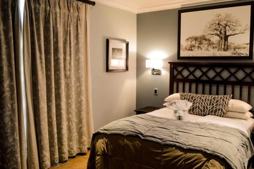 a bedroom with a bed and a window at Indaba Hotel, Spa & Conference Center in Johannesburg