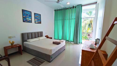 a bedroom with a bed and a large window at Green Hill Mirissa in Mirissa
