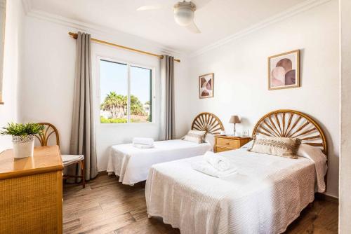 a hotel room with two beds and a window at Villa Pepita in Binibeca