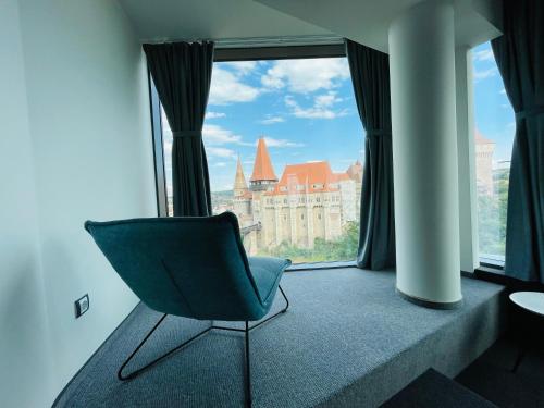 una sedia in una stanza con una grande finestra di WERK Hotel & SPA a Hunedoara