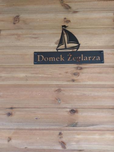 a sign on a wooden wall with a boat on it at Domek Żeglarza in Borsk