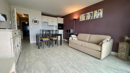 a living room with a couch and a table at Appartement avec balcon vue mer in Merlimont