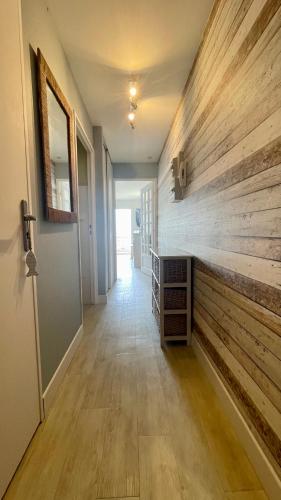 a hallway with a wooden accent wall in a house at Appartement avec balcon vue mer in Merlimont