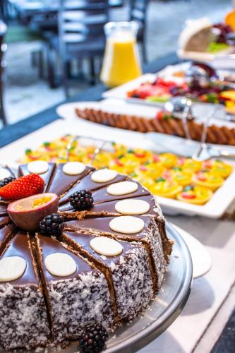 a chocolate cake with fruit on top on a table at Indaba Hotel, Spa & Conference Center in Johannesburg