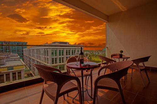 a room with tables and chairs and a window with a sunset at AJ Suites @ Loft Imago KK in Kota Kinabalu