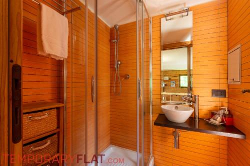 bagno con doccia in vetro e lavandino di TEMPORARYFLAT MONT CHETIF a Courmayeur