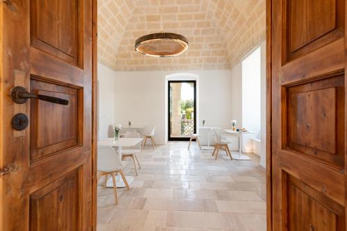 una porta aperta per una sala da pranzo con tavoli e sedie di Mastropà Exclusive Resort a Massafra
