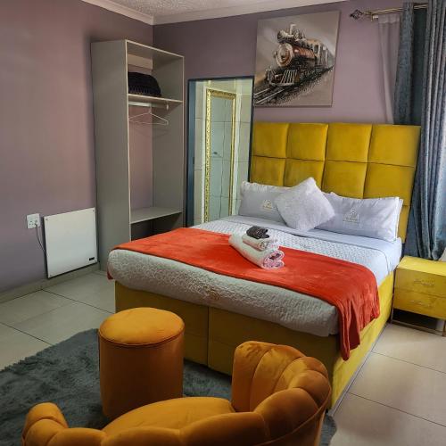 a bedroom with a large bed with a yellow headboard at High BnBGuestlodge in Johannesburg