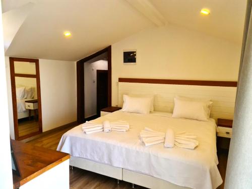a bedroom with a large white bed with towels on it at in Ephesus Hotel and Art Galery in Selcuk