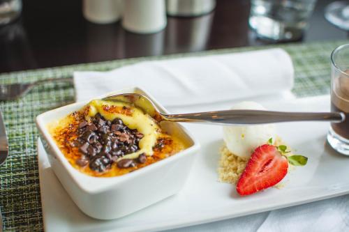 a white plate with a bowl of chili and a strawberry at Indaba Hotel, Spa & Conference Center in Johannesburg