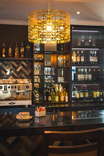a bar with a chandelier and a counter at Indaba Hotel, Spa & Conference Center in Johannesburg