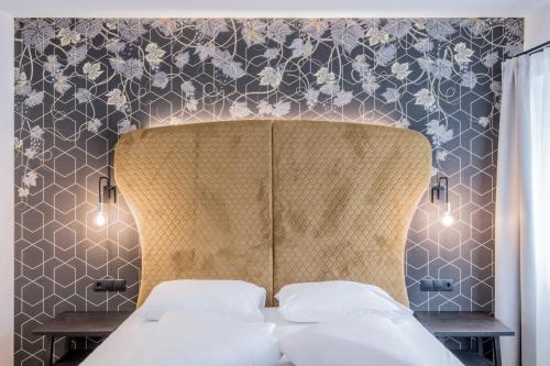 a bedroom with a bed with a floral patterned wall at B&B Zur Traube in Vipiteno