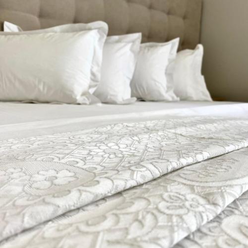a white bed with white pillows and white sheets at House of A&Arwen in Sarandë