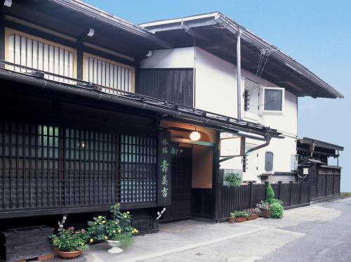a building with potted plants in front of it at Sumiyoshi Ryokan in Takayama