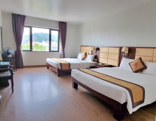 Una habitación de hotel con dos camas y una ventana. en LUXURY II HOTEL, en Ha Long