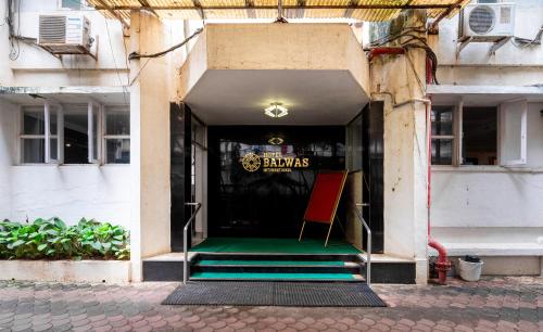 an entrance to a building with a green floor and stairs at Hotel Balwas International in Mumbai