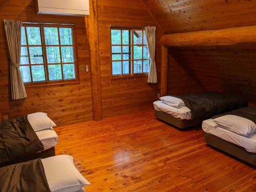 En eller flere senge i et værelse på White Tree Log House Madarao Tangram
