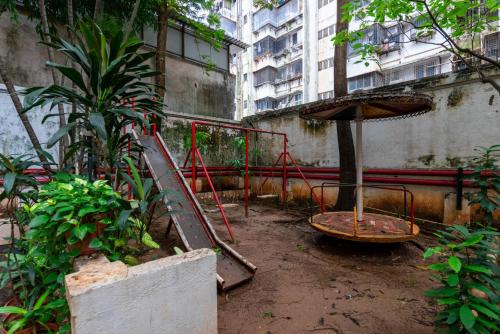 an abandoned garden with an umbrella and a playground at Hotel Balwas International in Mumbai