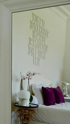 a mirror reflecting a bedroom with a bed with purple pillows at La Maison des Roses in Moulins