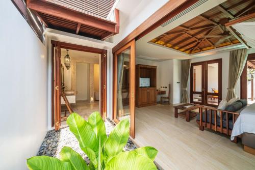 een slaapkamer met een bed en een woonkamer bij Malisa Villa Suites - SHA Extra Plus in Kata Beach