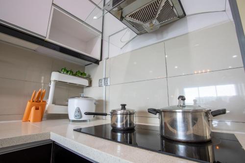 two pots sitting on a stove top in a kitchen at AJ Suites @ Loft Imago KK in Kota Kinabalu