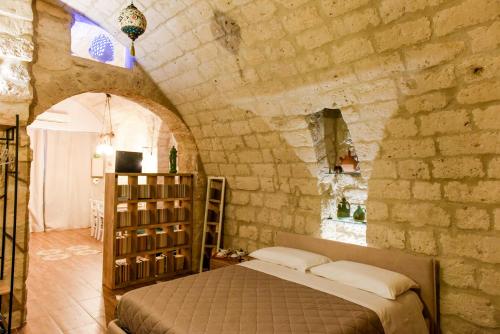 ein Schlafzimmer mit einem Bett in einer Steinmauer in der Unterkunft Nicola's House Luxury Loft in Bari
