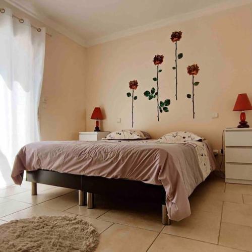 - une chambre avec un lit orné de fleurs sur le mur dans l'établissement Villa des Pins - Jolie villa proche de la plage, au Grau-dʼAgde