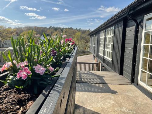 a wooden bench with flowers on the side of a building at Davids Kulle in Ronneby