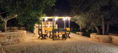 a table and benches in a park at night at Villa "Il Trullo di Filomena" in Castellana Grotte