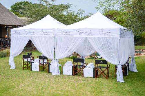 a white tent with chairs in the grass at Indaba Hotel, Spa & Conference Center in Johannesburg