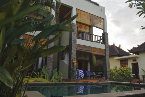 a house with a swimming pool in front of it at Bali Blue Gecko Villas in Amed