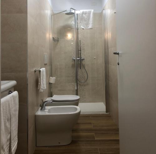 a bathroom with a shower and a toilet and a sink at Hotel Italia in Sacile