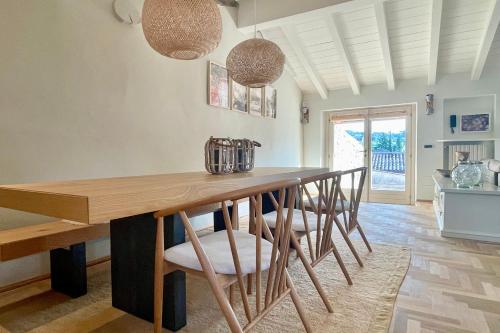 a dining room with a wooden table and chairs at Borgo dei Sogni - Unique Loft - Lago di Garda in San Felice del Benaco