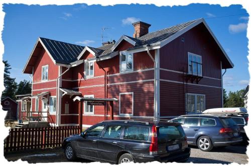 a house with a car parked in front of it at Furudals Vandrarhem och Sjöcamping in Furudal