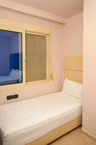 a small bedroom with a bed and a window at Aliko Hotel in Vlorë