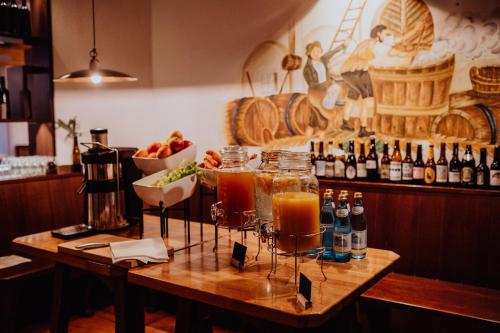 a bar with two glasses of drinks on a wooden table at Martinerhof's Brauhotel in San Martino